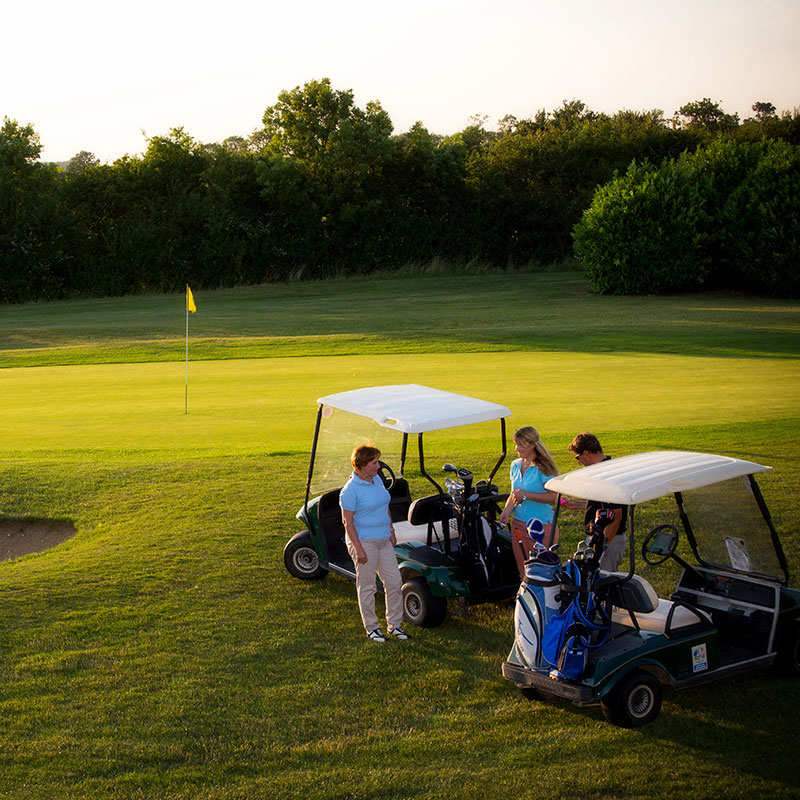 golf cart and players near the green
